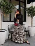 YEZWE Black Mock Neck Bell Sleeve Top & Zebra Print High Waist Flared Maxi Skirt styled in an outdoor setting