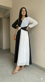 young woman wearing a black and white dual tone modest maxi dress posing sideways full length indoor view