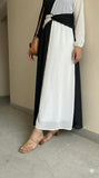 close up view of black and white dual tone modest maxi dress showing skirt detail and lower portion