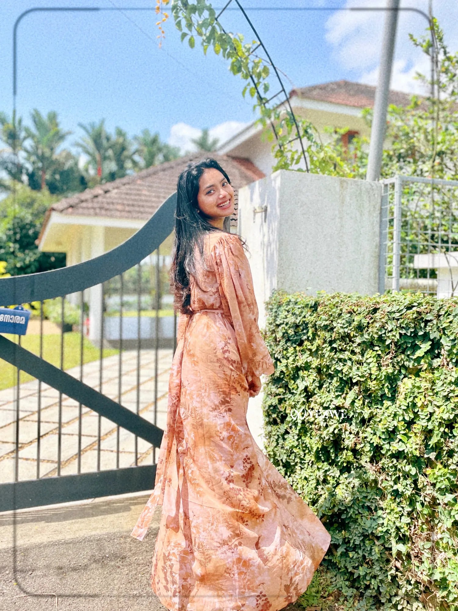 Yezwe brown floral georgette maxi dress flowing elegantly in a sunny outdoor setting