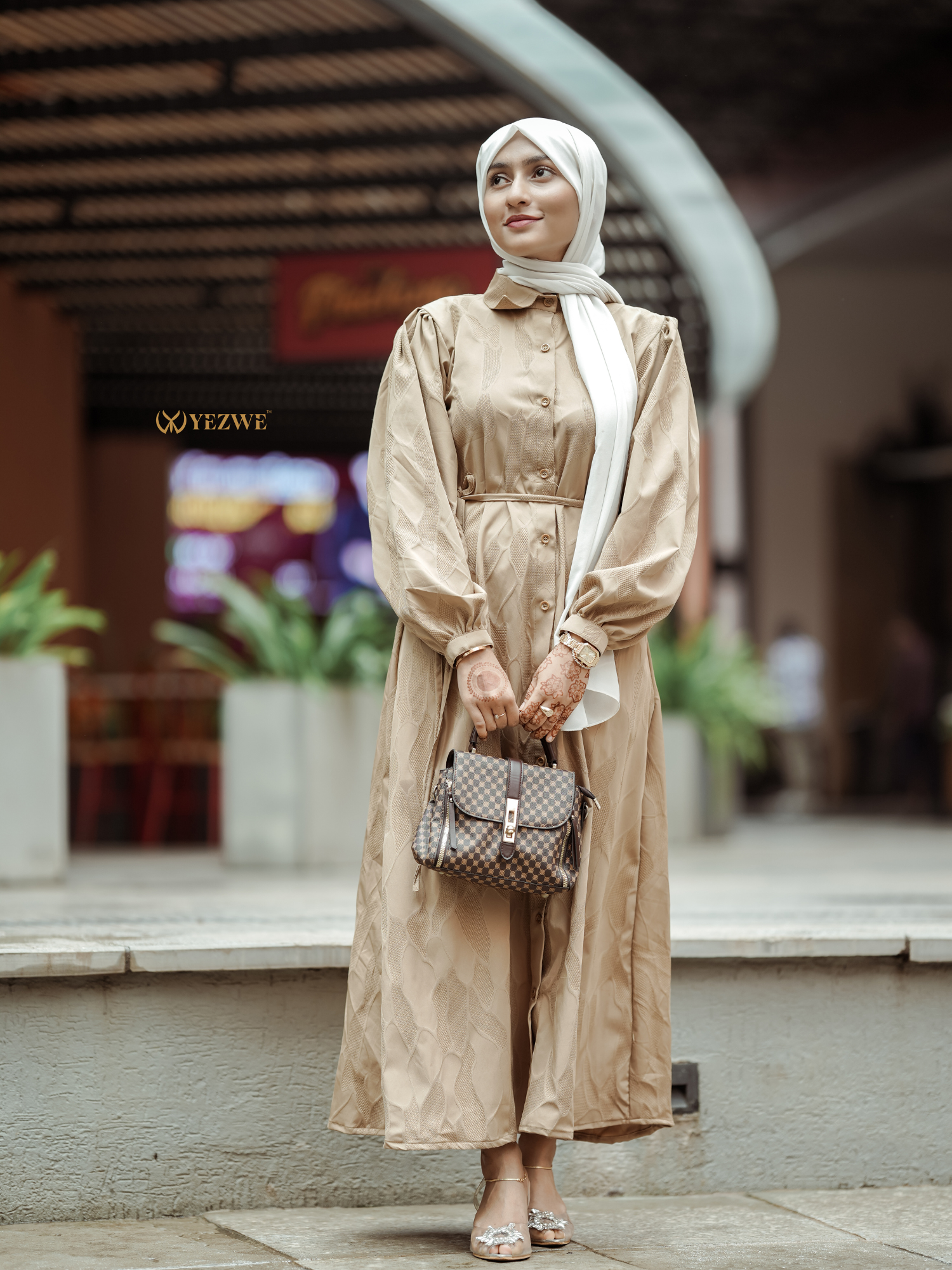 Yezwe brown textured maxi dress with button details and long sleeves, styled with a handbag