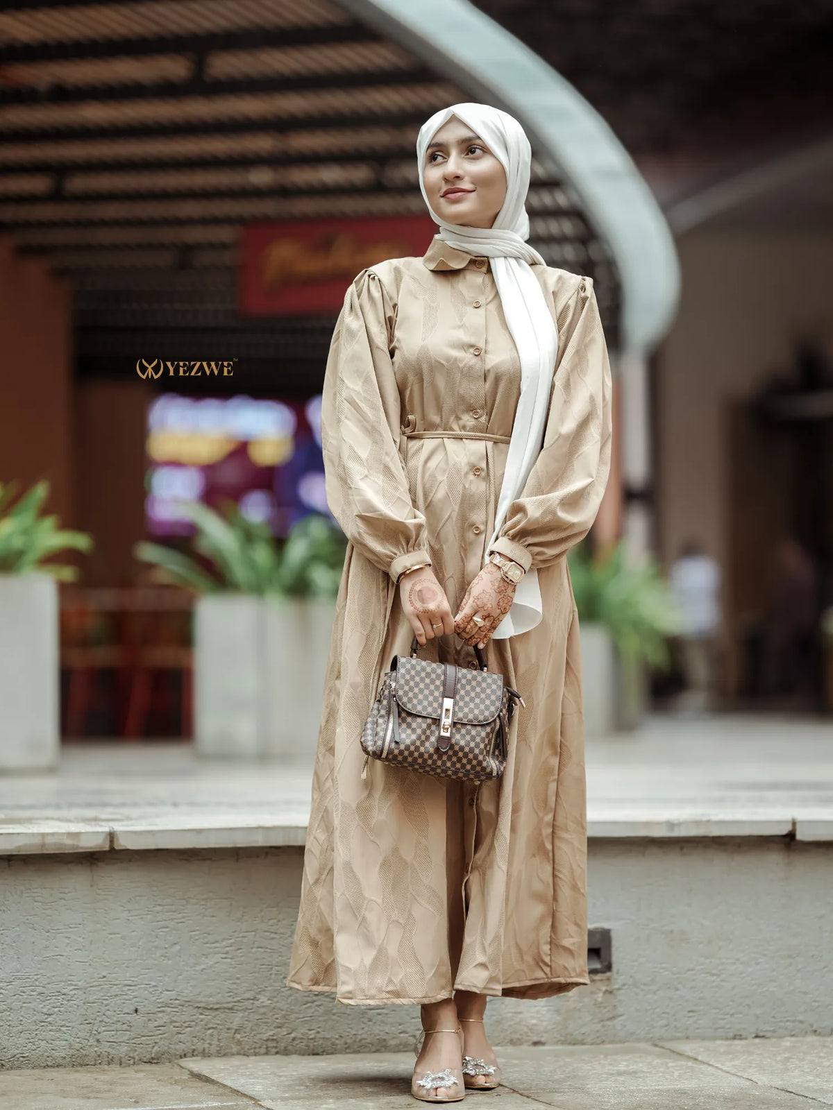 Yezwe brown textured maxi dress with button details and long sleeves, styled with a handbag