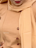 Close-up of a model wearing a camel brown modest co-ord set with decorative buttons and matching scarf