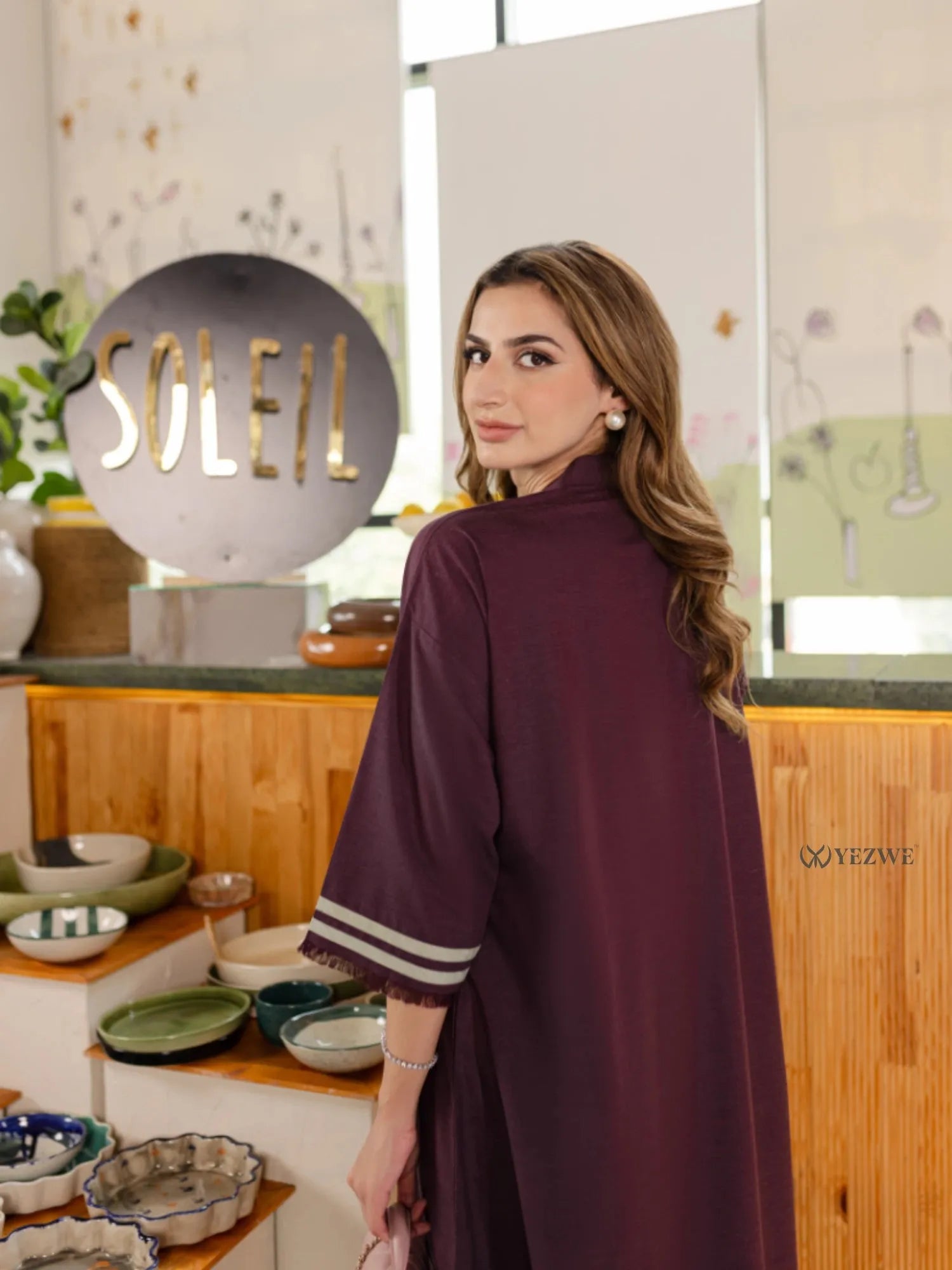 YEZWE burgundy Co-Ord Set with striped sleeve detail modeled indoors near decorative kitchenware