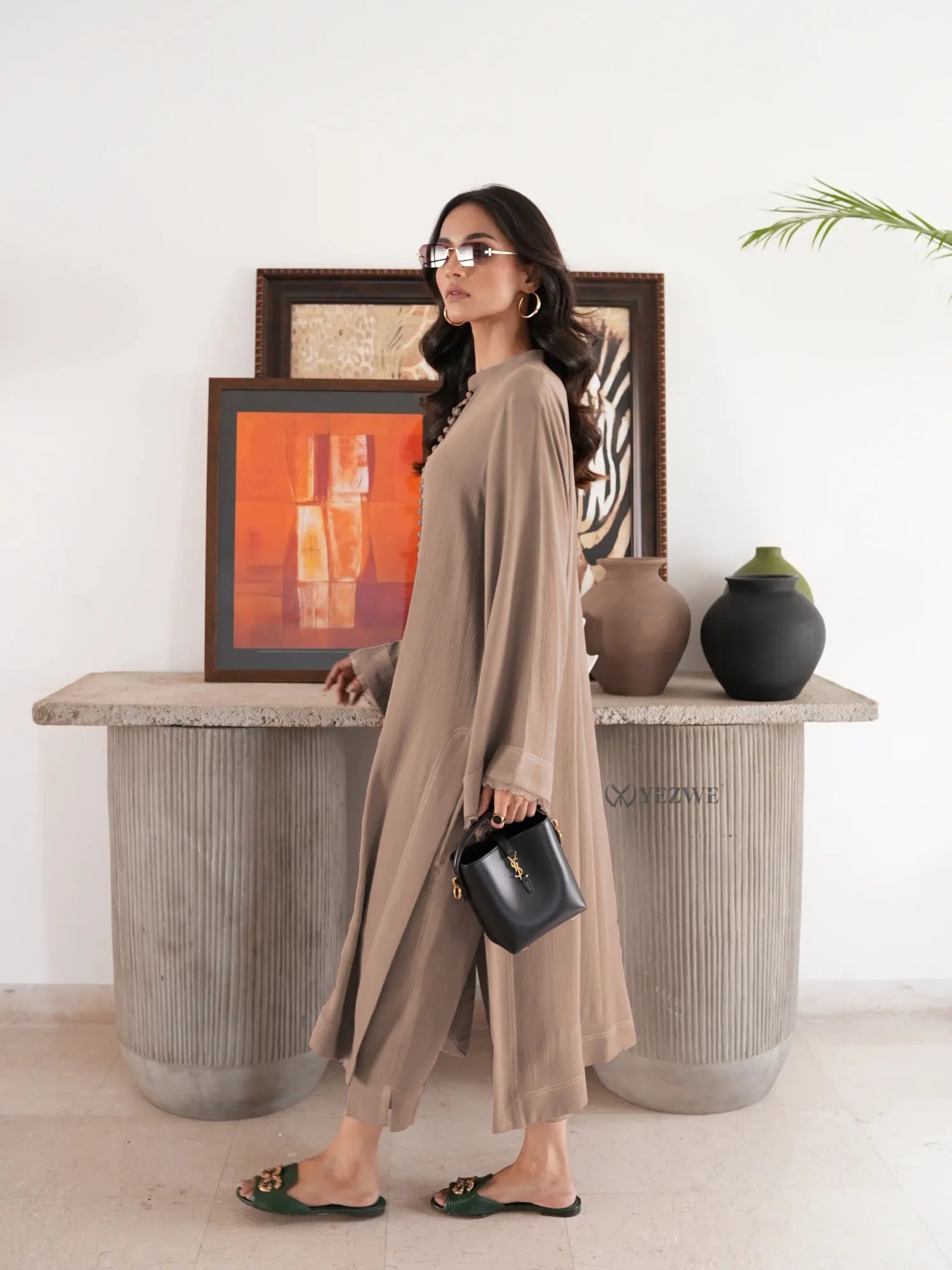 Woman wearing beige YEZWE Co-Ord Set with long sleeves and matching pants holding a black handbag