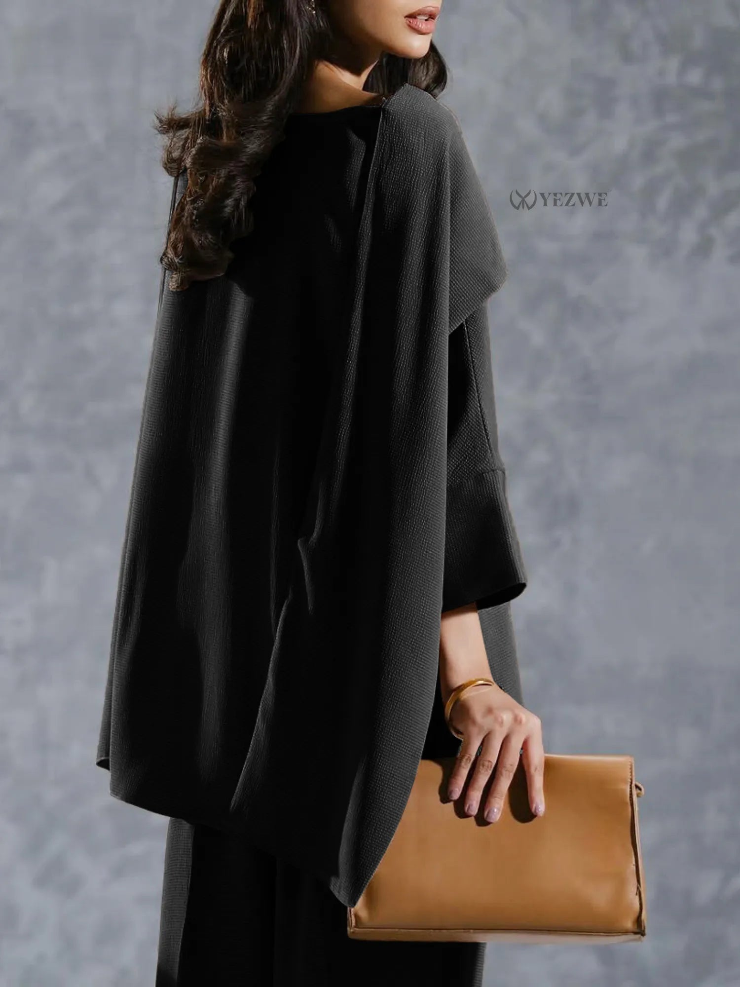 YEZWE black Co-Ord Set featuring loose long sleeve top paired with matching pants and tan clutch