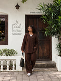 Woman wearing YEZWE Dark Brown Premium Linen Wrap Top Modest Co-Ord Set For Women, walking near a cafe.