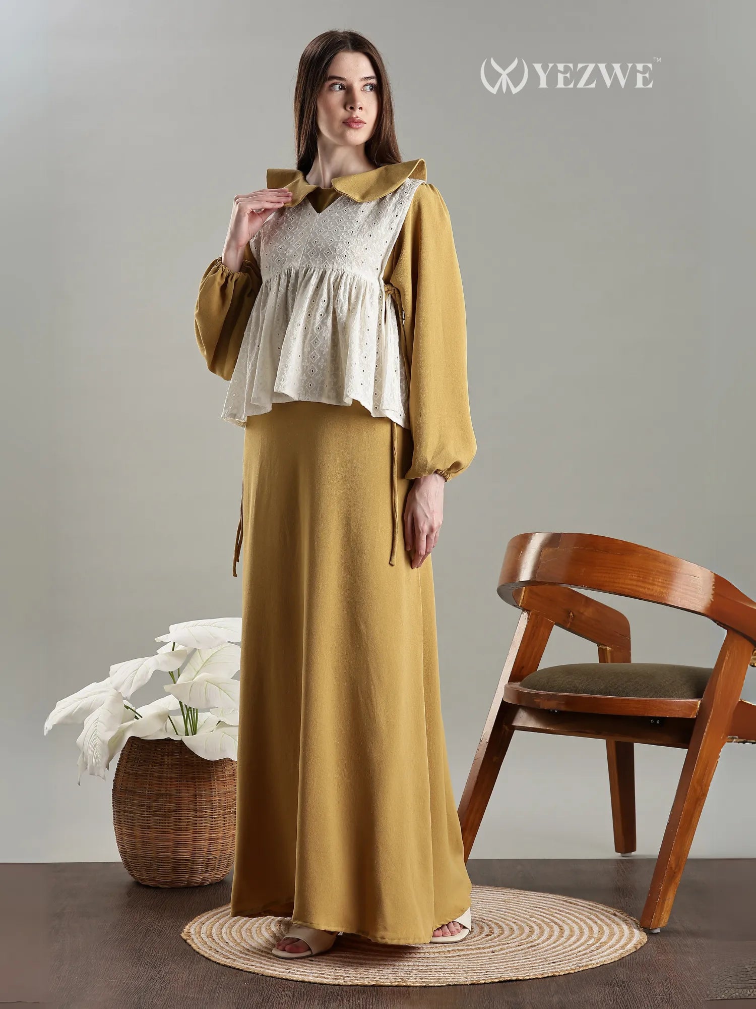 Golden Modest Maxi Dress with Hakoba Shrug by YEZWE worn by model standing near chair and decor