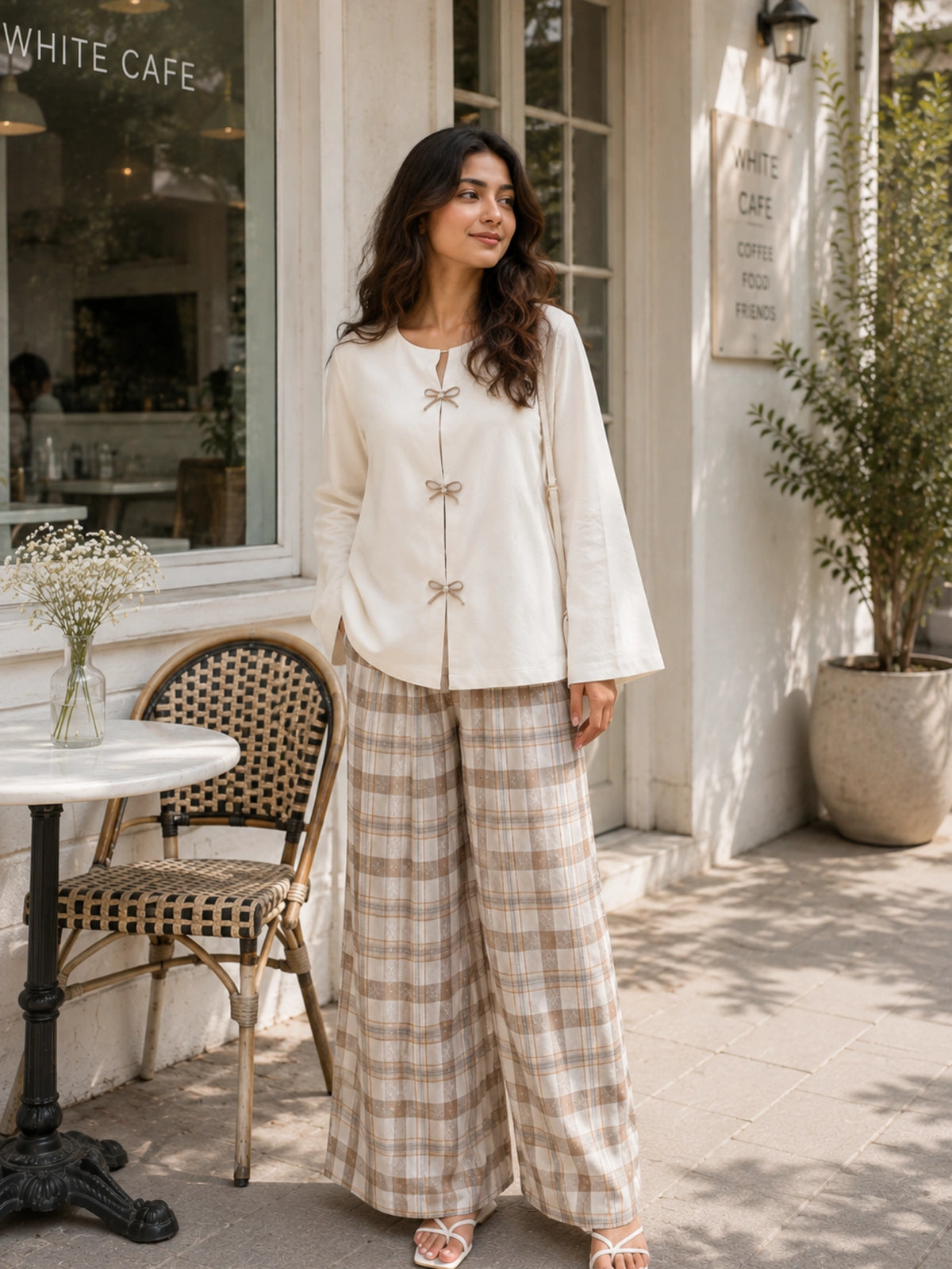 YEZWE Ivory Bow Cey Top And Plaid Modest Co-Ord Set For Women in a stylish outdoor café setting