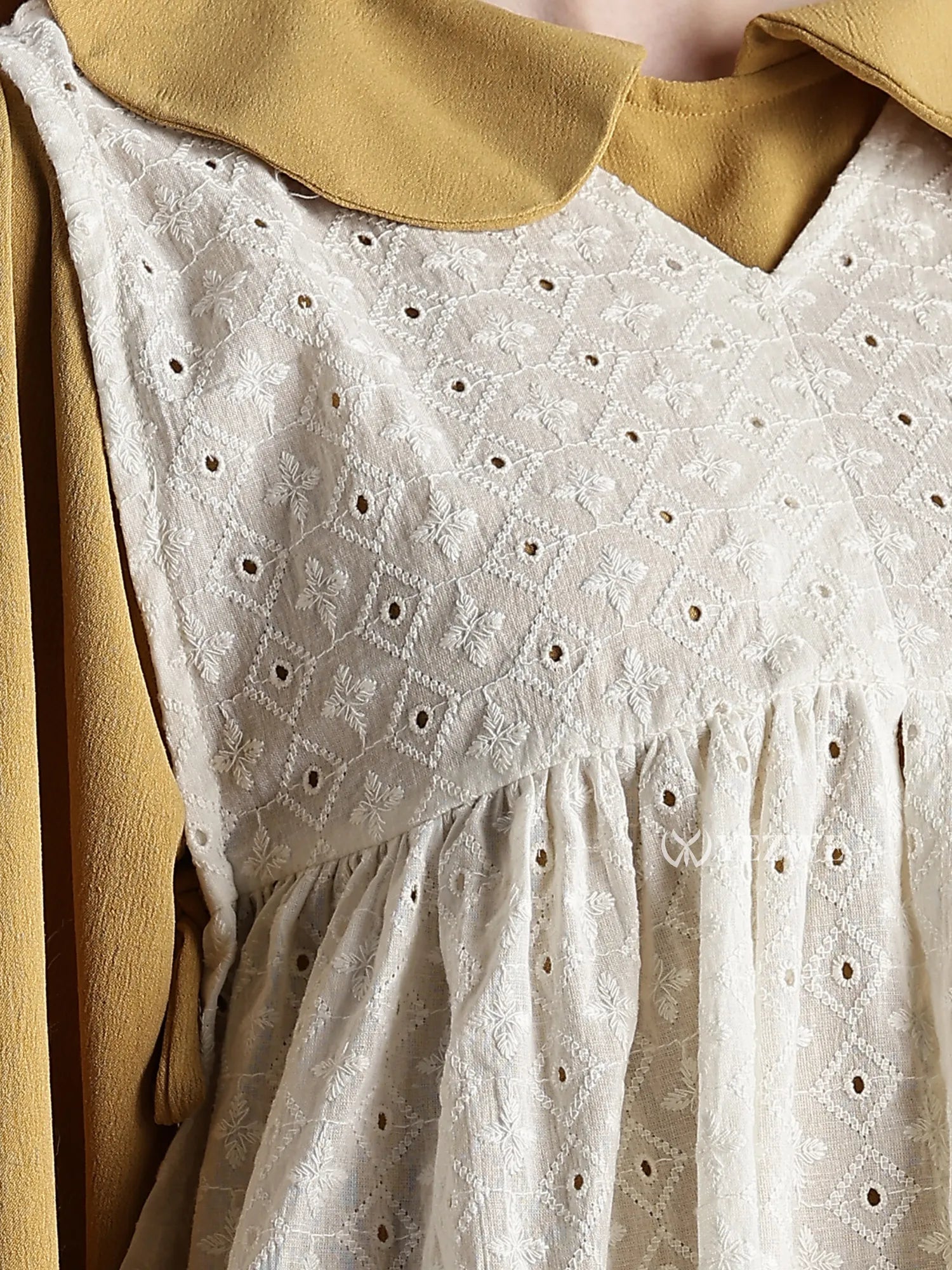Close-up of Junior Girls Maxi Dress with Hakoba Shrug featuring white embroidered fabric and mustard shrug collar