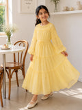 Young girl twirling in a pastel yellow flowy tiered maxi dress with long puff sleeves in a bright indoor café-style setting.