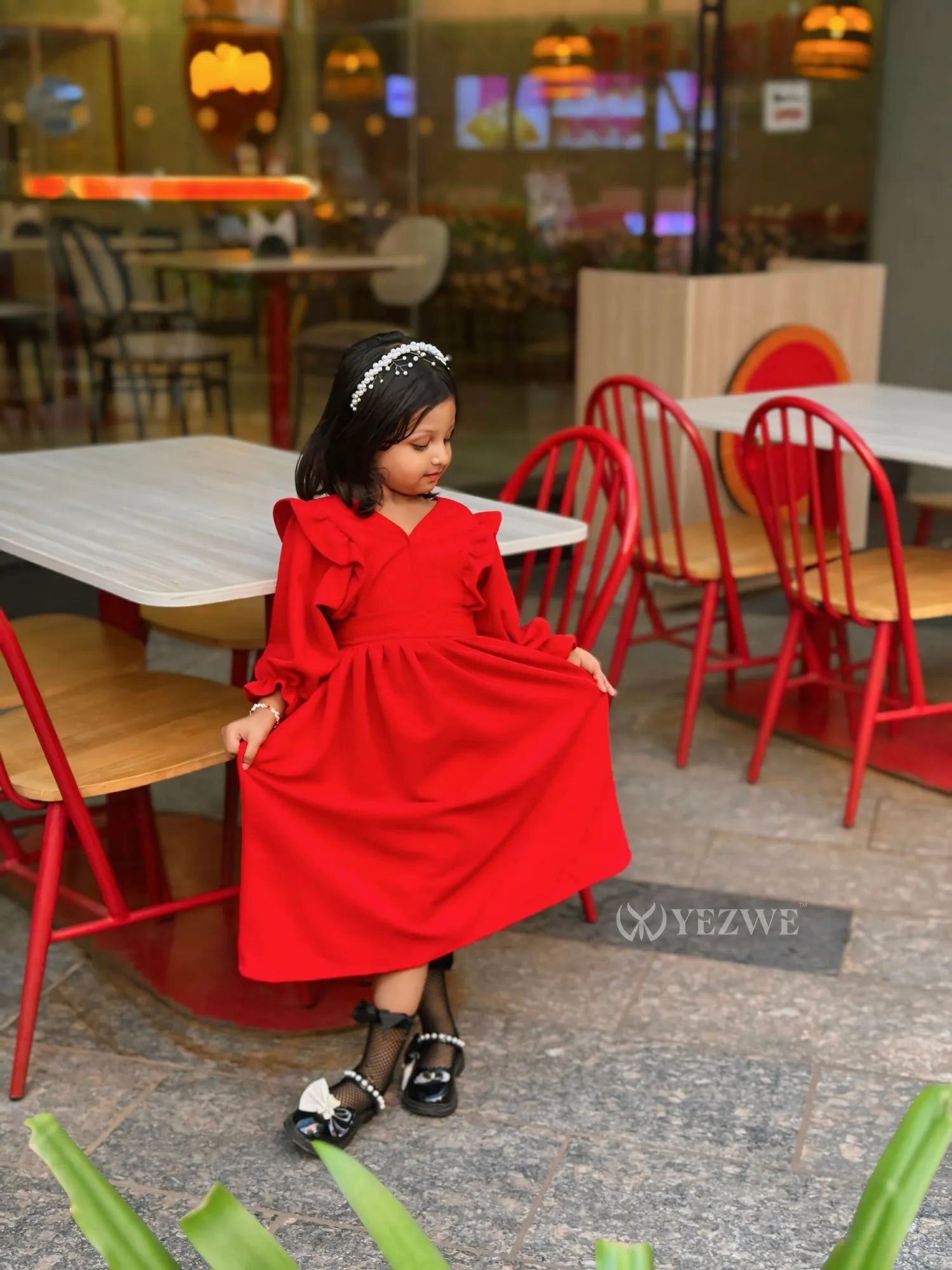 Junior girl wearing red YEZWE maxi dress for junior girls with ruffle sleeves and black shoes