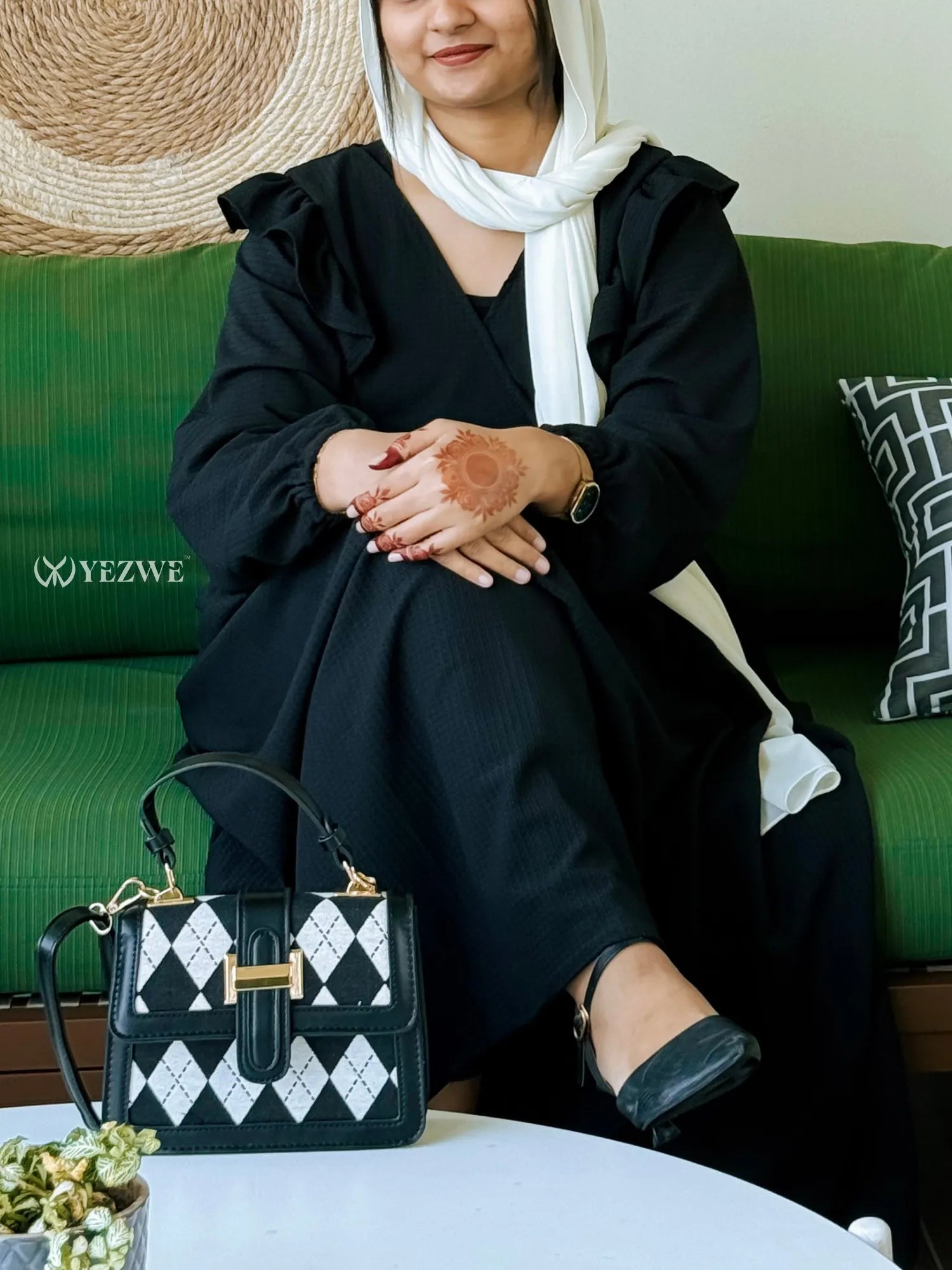 Yezwe modest black maxi dress with ruffled sleeves, styled with a chic handbag