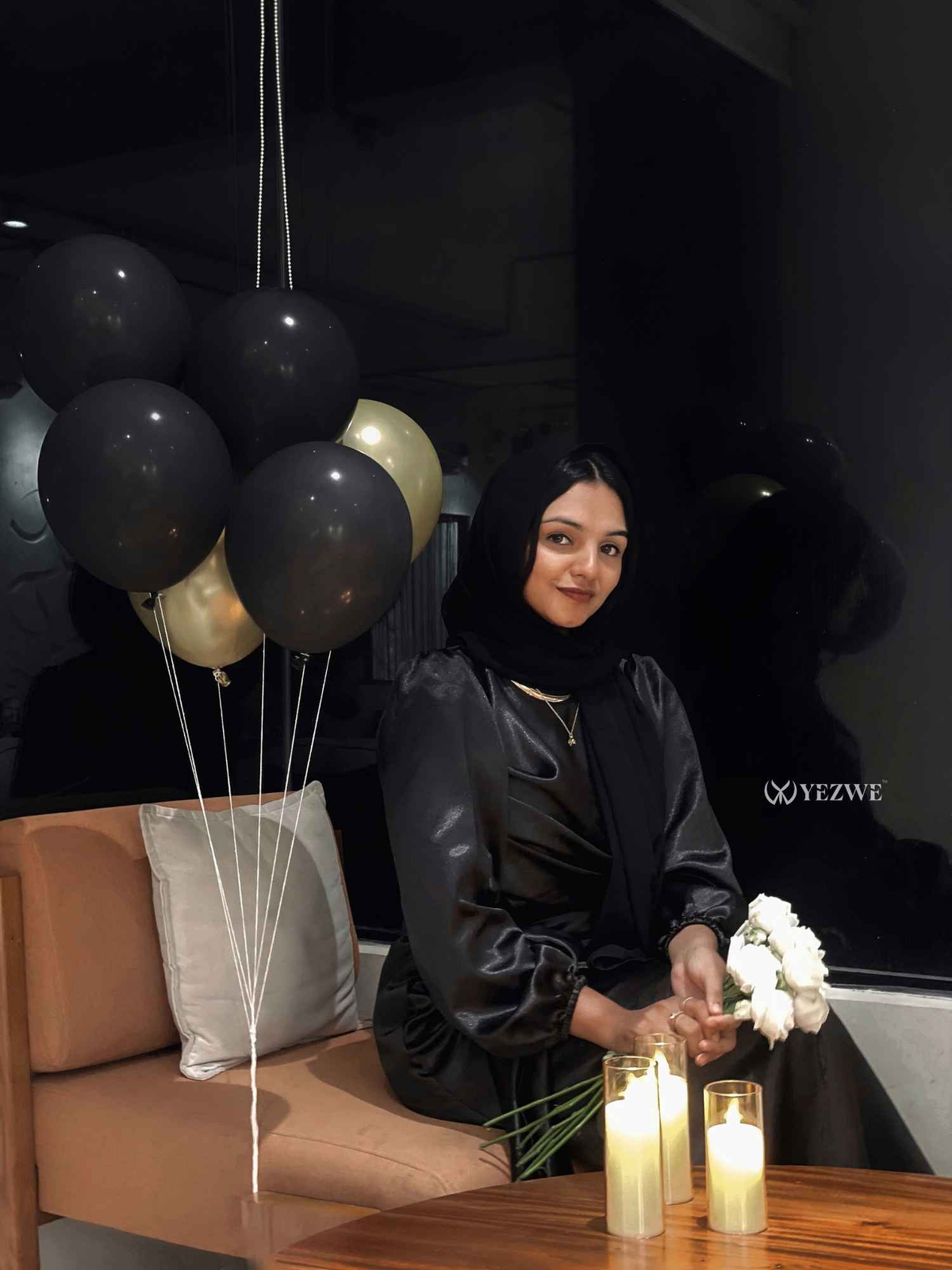 Elegant modest black satin maxi dress by Yezwe, styled with balloons and candles for a chic look.