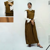 Modest brown dungaree outfit layered over a white blouse with ruffled details