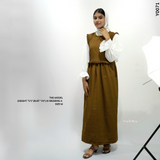 Model wearing a modest brown dungaree outfit, styled with white sleeves and sandals for a chic look