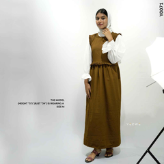 Model wearing a modest brown dungaree outfit, styled with white sleeves and sandals for a chic look
