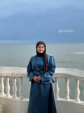 Woman wearing YEZWE Modest Co-Ord Set in dark teal with long sleeves and matching skirt by the seaside