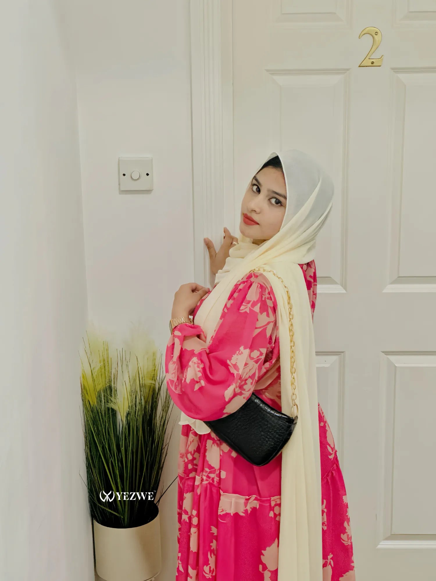 Model wearing a modest floral maxi dress from Yezwe, showcasing vibrant colors and elegant design