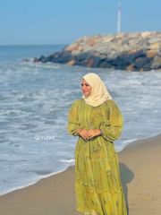 Yezwe modest green floral maxi dress flowing by the beach with ocean backdrop