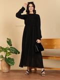 YEZWE black long sleeve Modest Maxi Dress on smiling model with pleated skirt black handbag and sandals