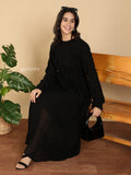 YEZWE Modest Maxi Dress black long sleeve flowy maxi on seated model holding handbag and sandals