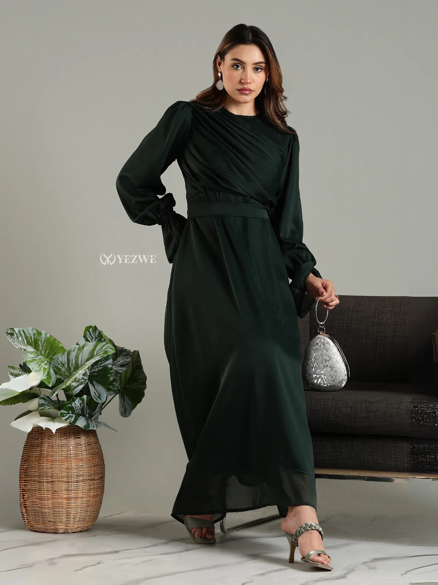 Yezwe modest maxi dress in dark green with long sleeves and a cinched waist worn with heels