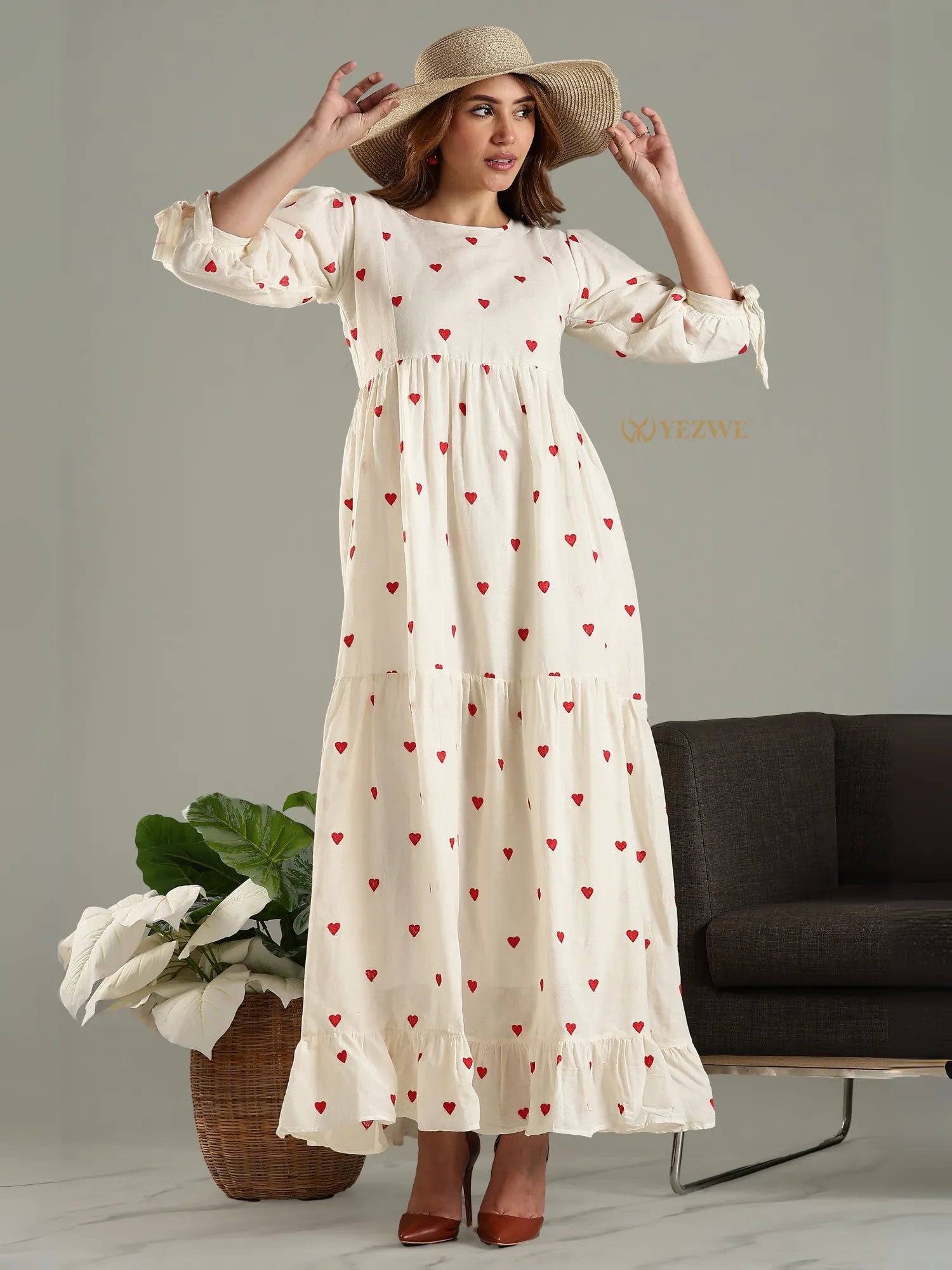 Yezwe modest maxi dress in cream with red heart print and long puff sleeves styled with a wide-brim hat