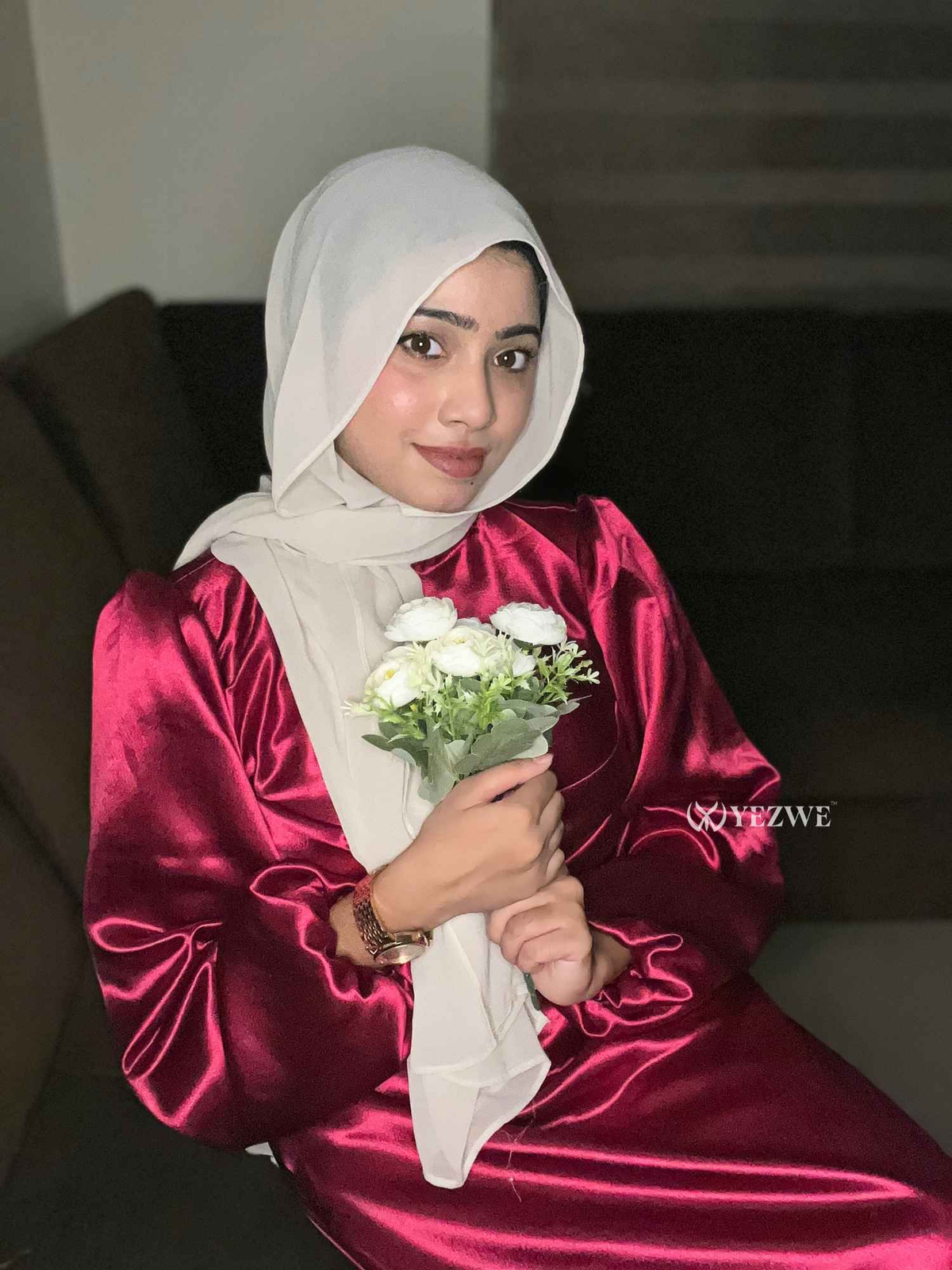 Model wearing a modest rosewood maxi dress from Yezwe, holding a bouquet of flowers