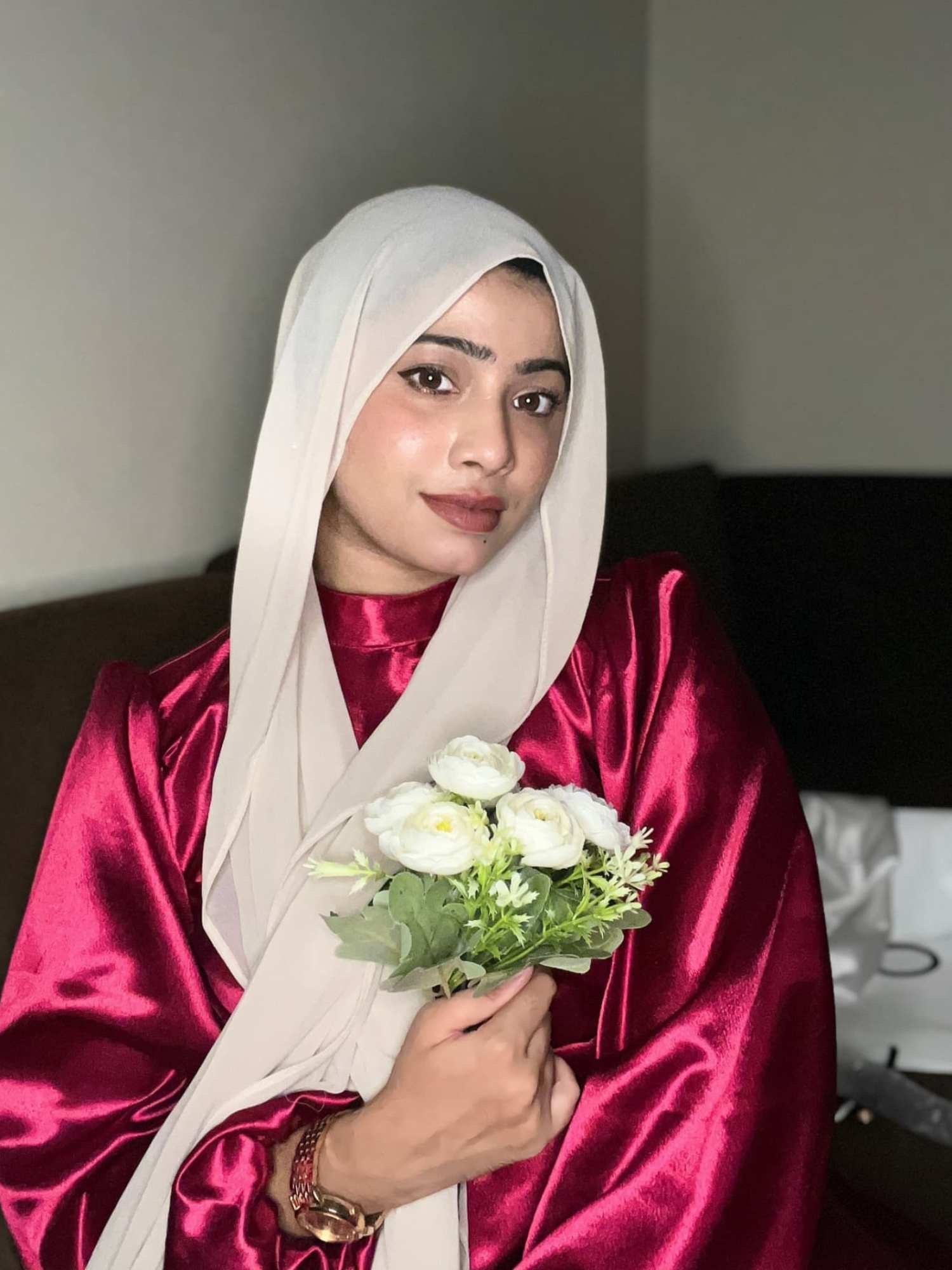 Elegant model wearing a modest rosewood maxi dress, holding white flowers and styled with a hijab
