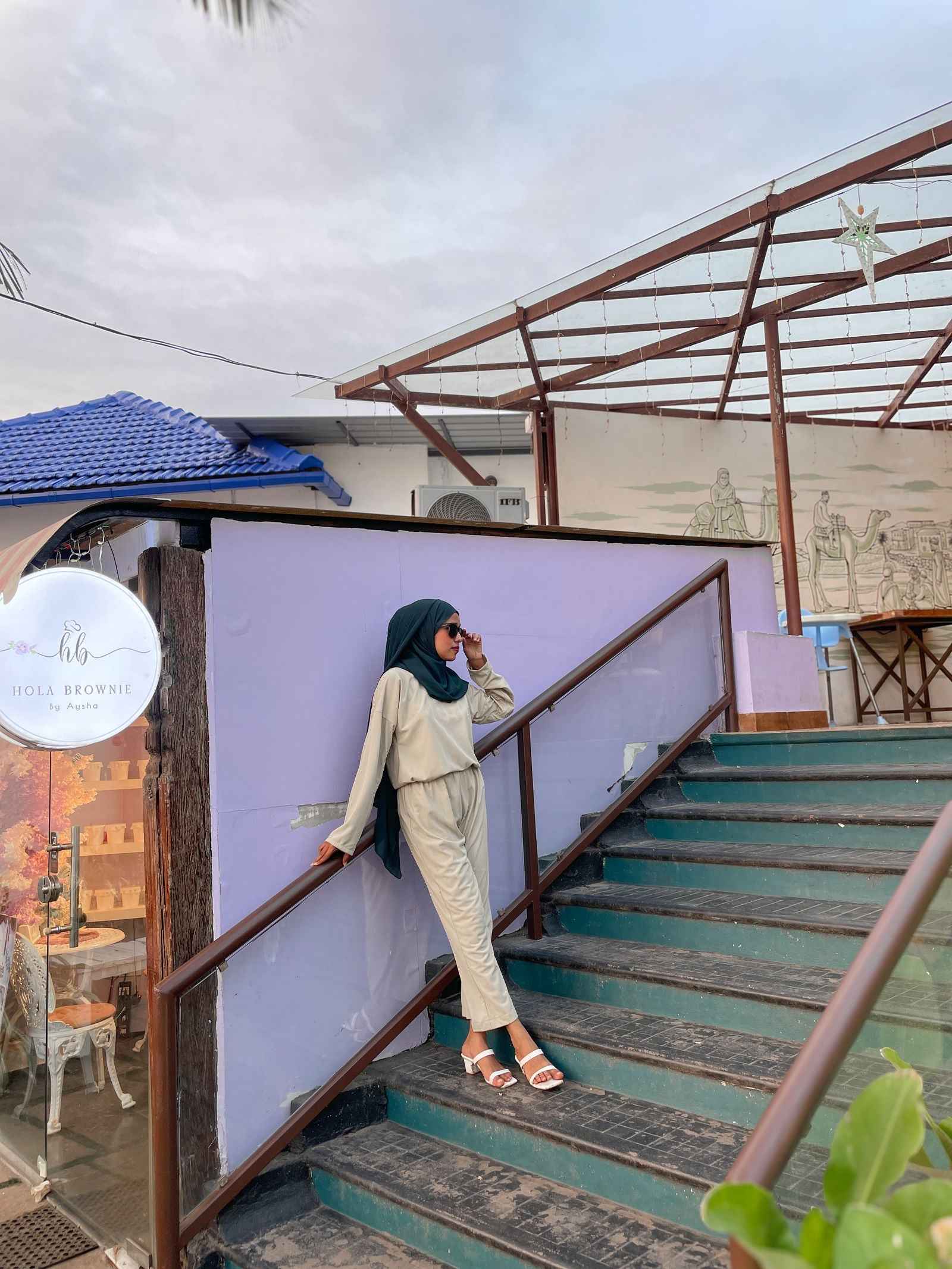 Yezwe modest wear featuring a stylish top and pant set worn on a staircase outdoors