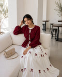 Pinterest Bow Detail White Flared Gown with Wine Cey Shrug | Yezwe Modest Wear showcased in a stylish setting
