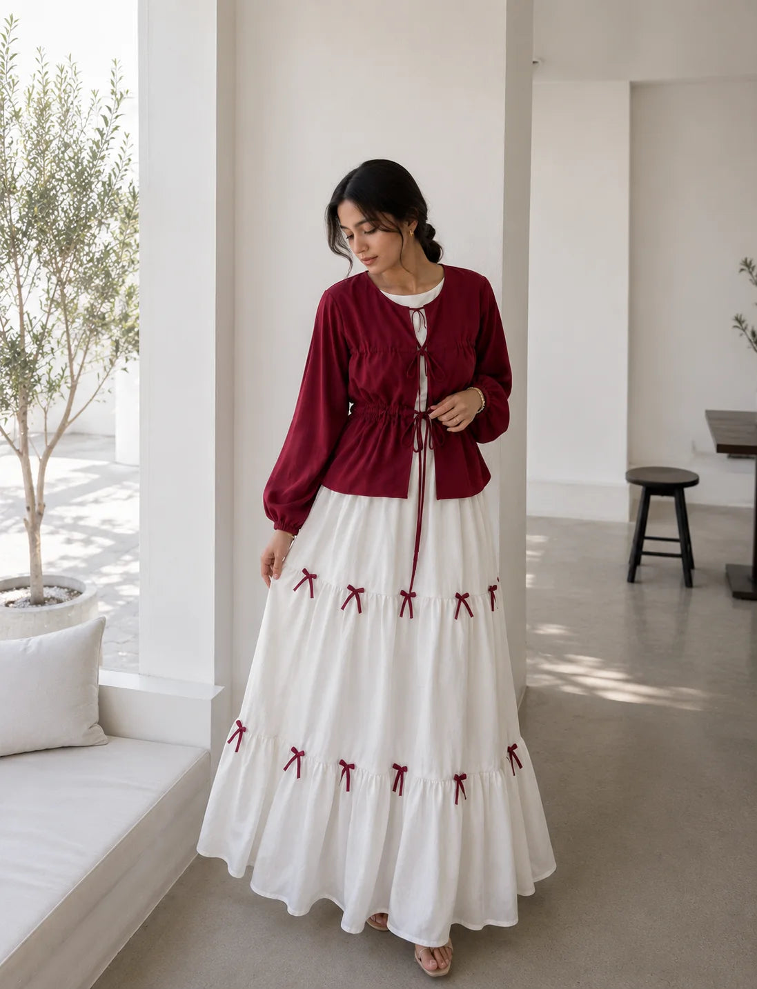 Pinterest Bow Detail White Flared Gown with Wine Cey Shrug | Yezwe Modest Wear styled in a bright, airy room