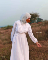 Modest white maxi dress by Yezwe with long sleeves and a flowing silhouette in an outdoor setting