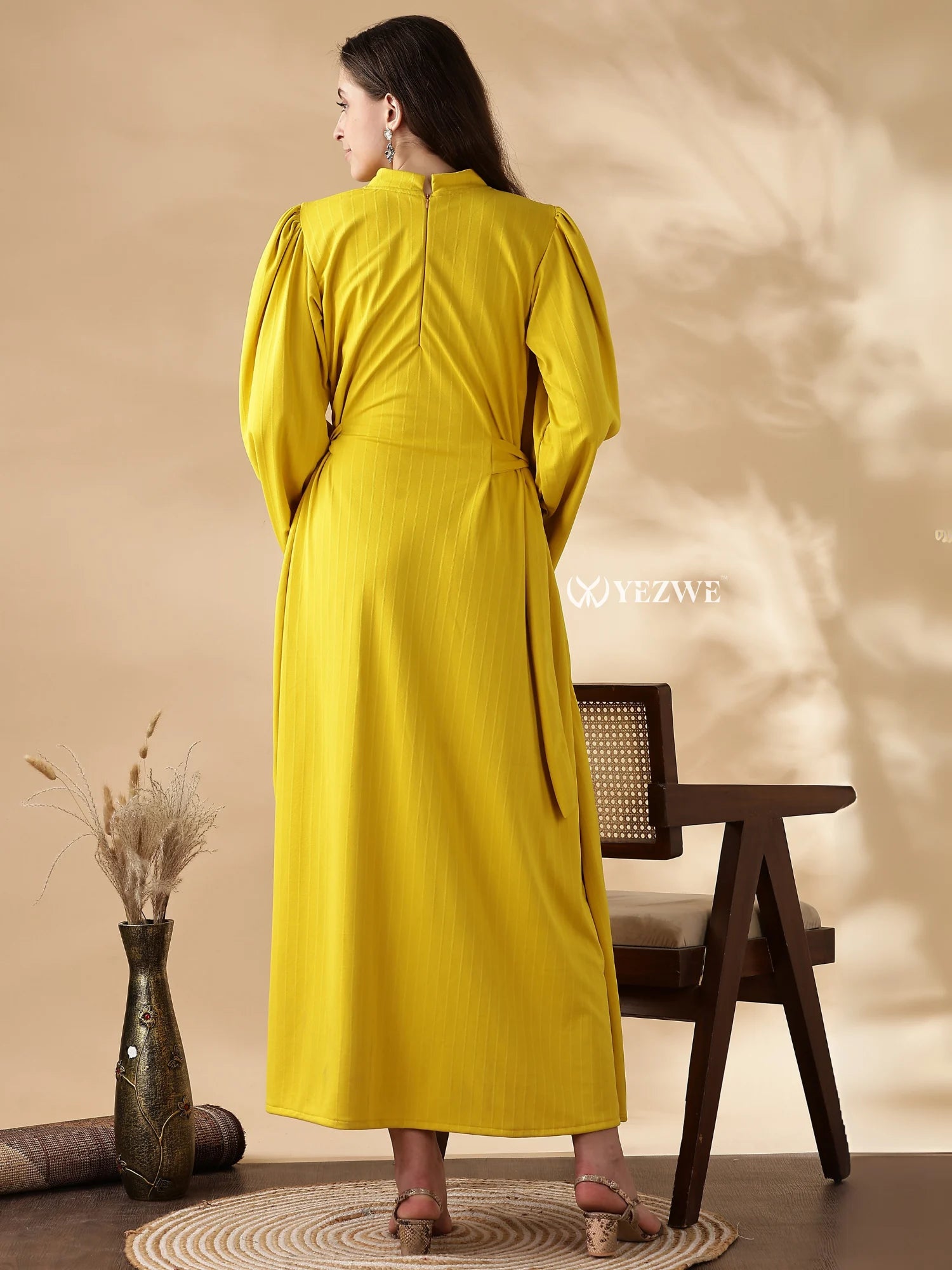 Back view of a modest yellow maxi dress by YEZWE with long sleeves and a flowy silhouette