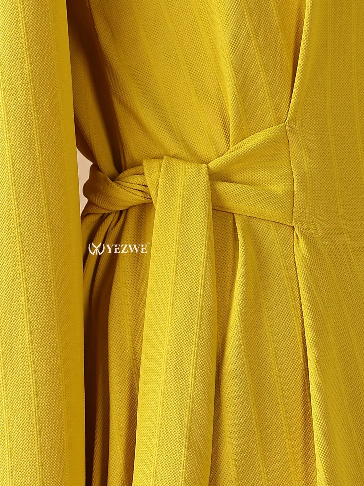 Close-up of the YEZWE modest yellow maxi dress featuring a tied waist and textured fabric