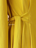Close-up of the YEZWE modest yellow maxi dress featuring a tied waist and textured fabric