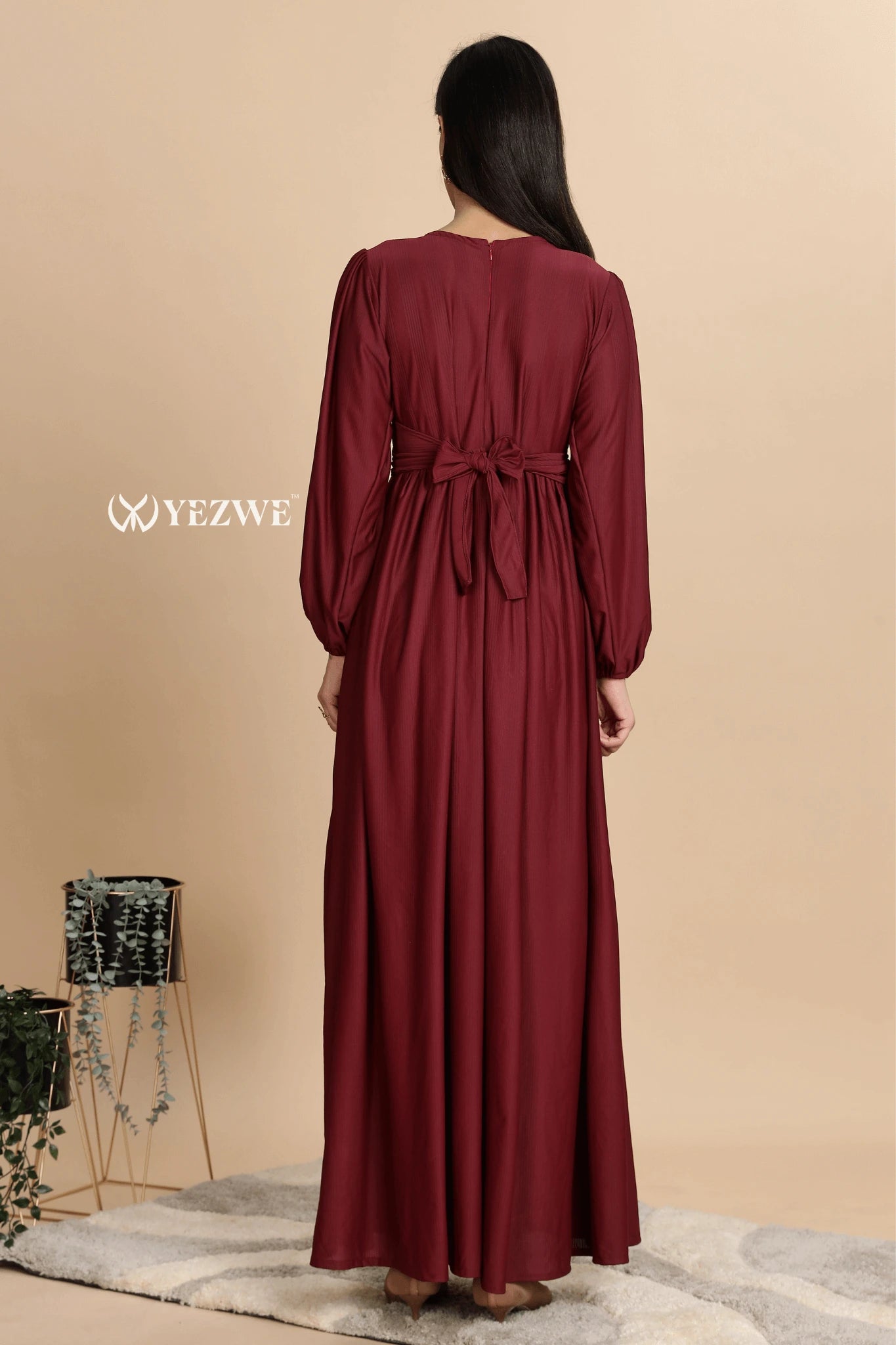 Back view of YEZWE Premium Modest Wear Dress in burgundy with a tied waist and flowing design