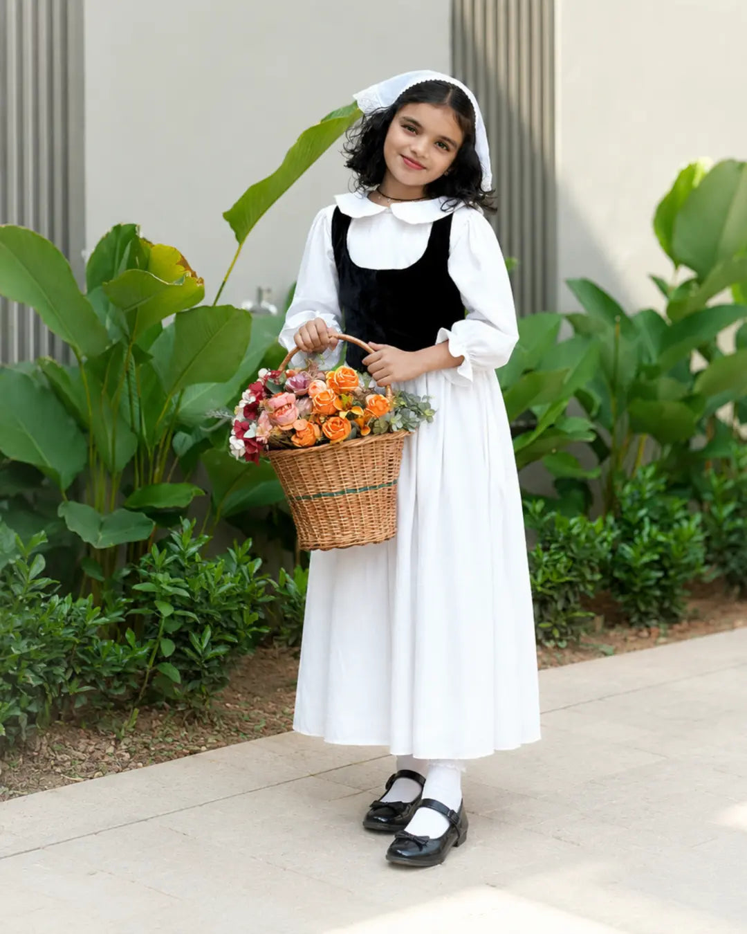 Junior girls in Yezwe Vintage Black Bodice Classic White Flared Maxi Dress holding a flower basket