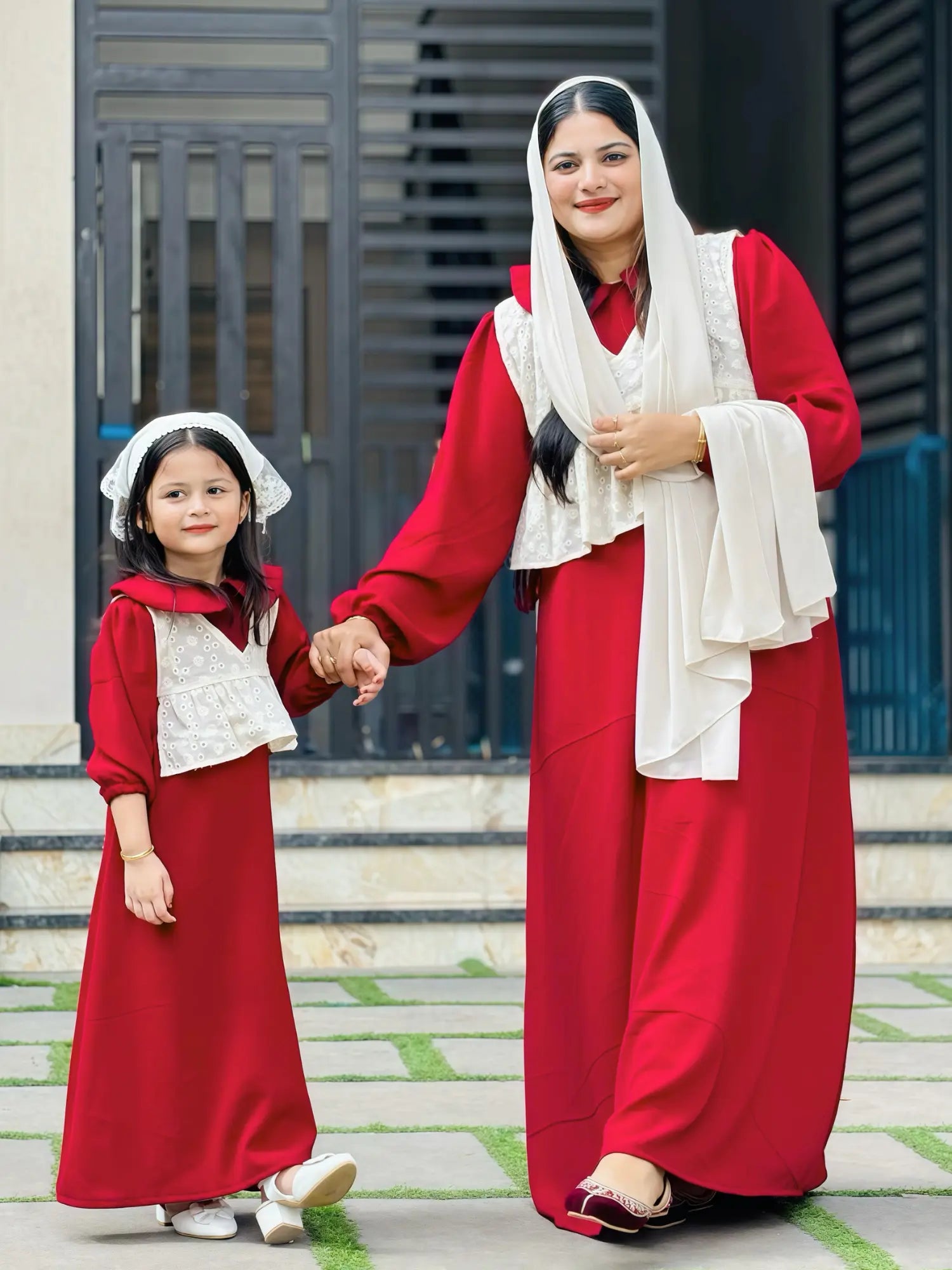 woman and young girl wearing matching wine maroon modest maxi dresses with cream layered tops and dupatta walking together outdoors