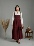 young woman wearing a wine maroon and white layered modest maxi dress side profile studio view