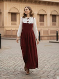 young woman wearing a wine maroon and white layered modest maxi dress walking outdoors on street full length view