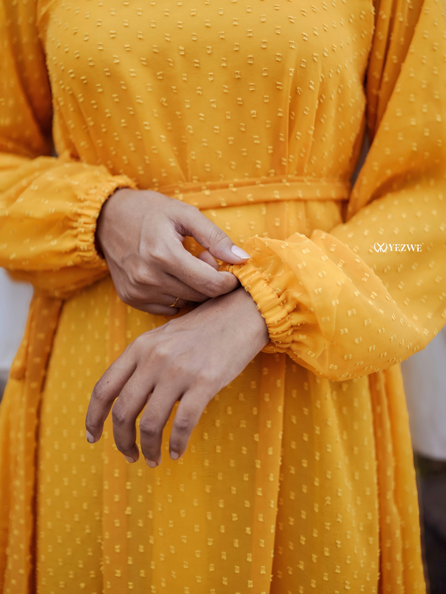 Close-up of sleeves on a yellow textured maxi dress by Yezwe, showcasing soft fabric and stylish design.